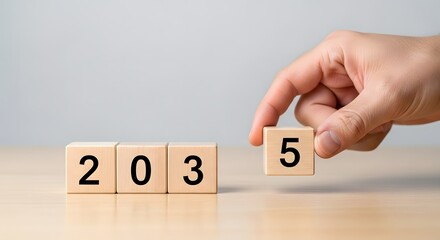 Year forecast concept hand arranging wooden blocks with numbers to represent year two thousand thirty five
