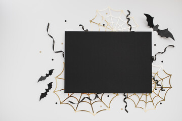 Halloween party template from empty black blank with festive decoration from bats, spider web, confetti on white background top view.