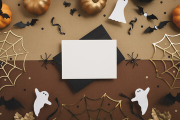 Halloween party composition with empty card from envelope with festive decoration from pumpkins,...