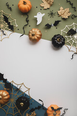 Happy Halloween party border template from pumpkins, bats, spider web, ghosts on vertical background top view.