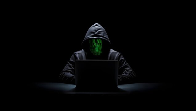 Anonymous hooded hacker programming on a laptop in the dark, representing cybersecurity threat and data breach.