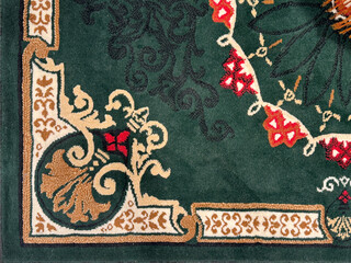 Close up of classic vintage European carpet rug texture. Seen here the floral swirls pattern with engraved ornamental decoration. In red, white, gold, and green color. Seamless background texture.