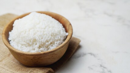 a wooden bowl of rice isolated on marble background