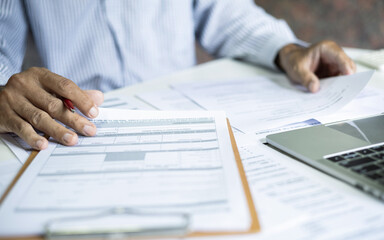 businessman or professional lawyer reviewing document at office. legal expert working with laptop checking financial documents and business contract