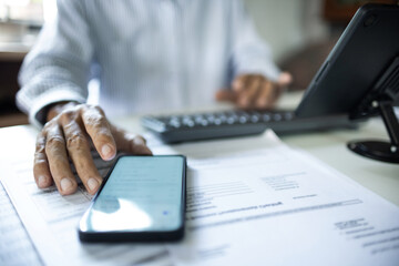 close up shot, asian businessman work at home using mobile phone, laptop connecting to customer,...