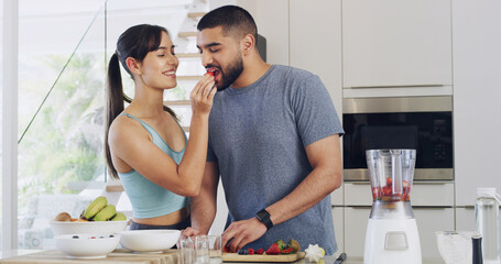 Feeding, home and couple in kitchen, strawberry and hungry with support, fruits and weight loss. Gut health, blender or man with woman, smoothie or nutrition with vitamins, relationship or eating