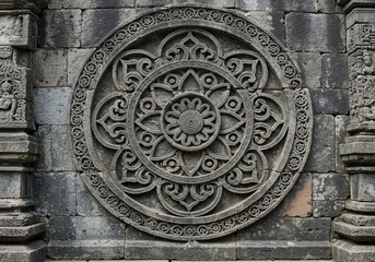 Ornate stone carving with intricate floral patterns displayed on an ancient temple wall
