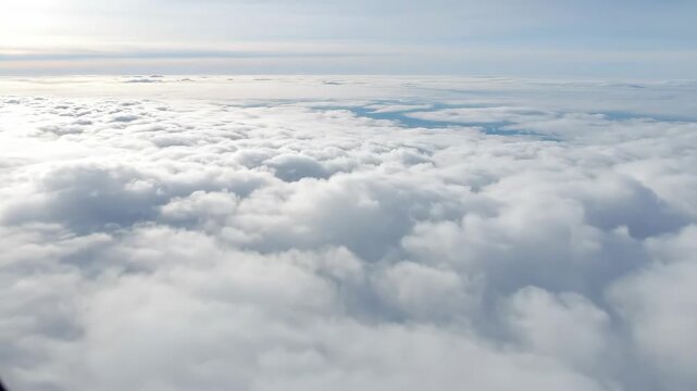 Above the Clouds: Breathtaking High-Altitude View - A stunning aerial perspective showcases a vast expanse of fluffy white clouds stretching to the horizon.