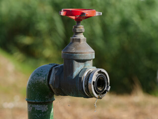 
Water tap with red handwheel, a small drop of water is visible, topic: water shortage, access to...