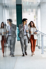 Fototapeta premium Businesspeople walking and talking in office corridor