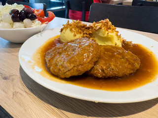 Delicious meat patties with mashed potatoes and salad on wooden table