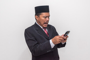 Formally Dressed Asian Man in Peci Hat Gasps in Utter Shock at His Smartphone