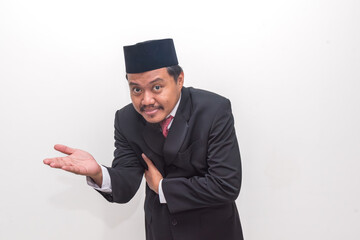 Charming Indonesian Man in Peci and Suit with a Persuasive, Welcoming Gesture