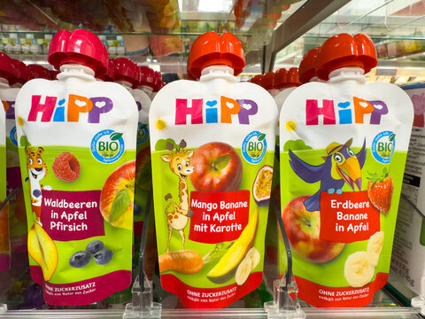 Villach, Austria - August 18, 2025: HiPP organic baby food pouches displayed on supermarket shelf, featuring fruit flavors like mango, strawberry, and wild berries in vibrant packaging
