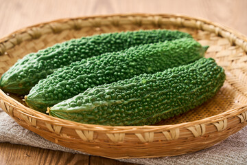 ゴーヤ｜沖縄の夏野菜を竹ざるに盛った食材イメージ