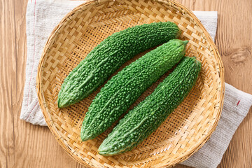 ゴーヤ｜沖縄の夏野菜を竹ざるに盛った食材イメージ