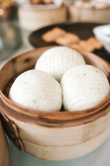 Close-up of steamed Chinese buns served in a traditional bamboo basket.