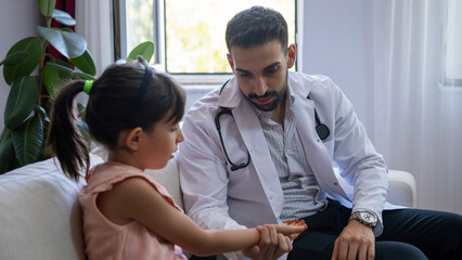 The young doctor checks his little patient's pulse.