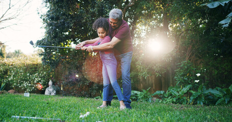Family, child and teaching golf in garden for learning, swing technique and bonding together. Helping, girl kid and grandfather playing sports in backyard with support, weekend activity and skills