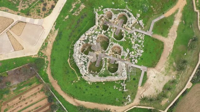Drone shot of Ggantija Archaeological Park in Gozo with ancient stone temple ruins on green land
