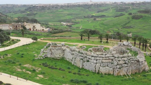Drone shot of Ggantija Archaeological Park in Gozo with ancient stone temple ruins on green land