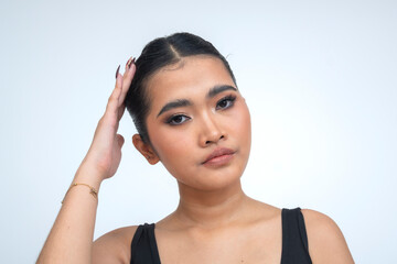 A striking young Asian woman in a close-up portrait, holding a strong gaze at the camera while...