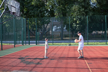 Naklejka premium Father and a son playing basketball