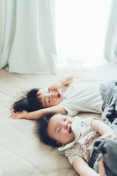 ベッドに寝転がる小さな姉妹