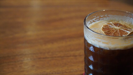 Refreshing glass of Jabarano black coffee infused with hive honey, topped with a dried lemon slice,...