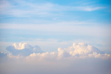 Fluffy cumulus clouds rise majestically along the horizon sky