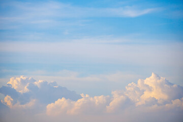 Fluffy cumulus clouds rise majestically along the horizon sky