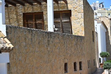 stary hiszpański budynek z kamienia z drewnianymi roletami © Miroslaw