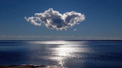 Obraz premium Single cloud over calm, sunlit sea