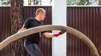 Septic service technician performing maintenance at residential property