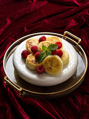 cottage cheese pancakes with raspberries on red velvet