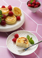 cottage cheese pancakes with raspberries and mint on pink background