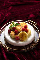 cottage cheese pancakes with raspberries on red velvet