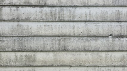The cement wall has old grey grooves, black stains, water marks and is dirty. The fence has been...