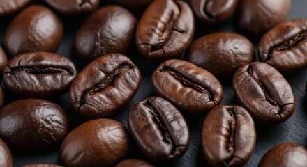 Fototapeta premium Closeup of roasted brown coffee beans on a dark surface