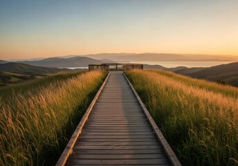 Wooden walkway leading to an overlook on a grassy hill at sunset
