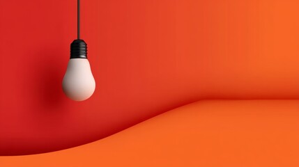 Light bulb hanging from a cord is the only object in the image. The red background and the light bulb create a sense of warmth and brightness