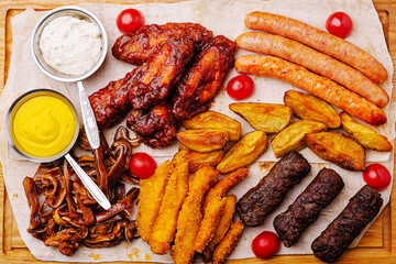 Delicious assortment of grilled meats and sides served on a wooden platter