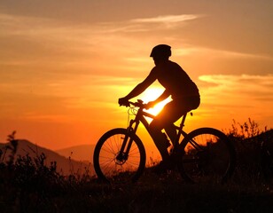 A silhouette of a cyclist riding a bicycle uphill at sunset