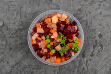 beetroot vinaigrette salad in a disposable plate on a gray concrete background
