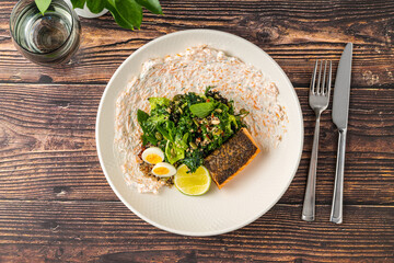 Fresh grilled salmon with greens, eggs, and creamy dressing