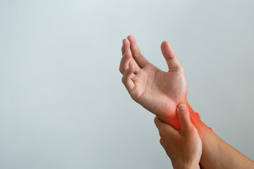 Close-up of a person holding a painful wrist with red highlight, concept of work injury, exercise strain, arthritis, tendon inflammation, and carpal tunnel syndrome health problem.