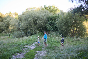 Obraz premium Mother and children hiking in the forest