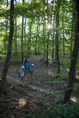 Obraz premium Mother and children hiking in the forest