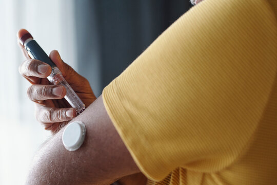 Person checking insulin using pen and patch for diabetes management