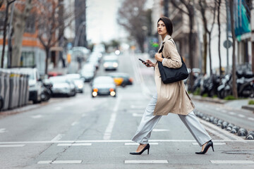 Professional woman walking confidently in stylish outfit on urban street